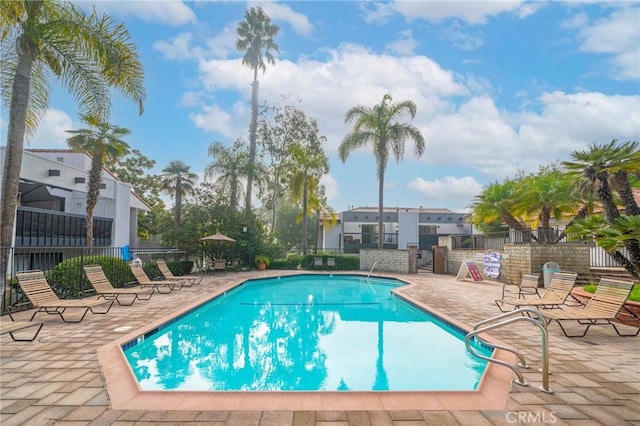 community pool featuring a patio and fence