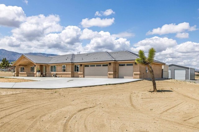 11374 Desert View Rd, Pinon Hills, CA 92372 - view of front facade featuring a tile roof, driveway, a garage, and stucco siding