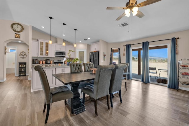 11374 Desert View Rd, Pinon Hills, CA 92372 - dining room featuring vaulted ceiling, arched walkways, ceiling fan, light wood-type flooring, and baseboards