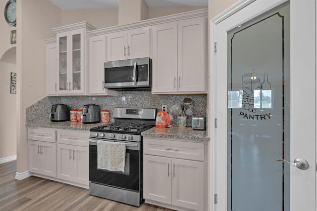 11374 Desert View Rd, Pinon Hills, CA 92372 - kitchen featuring stainless steel appliances, decorative backsplash, light wood-style floors, and white cabinetry