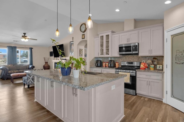 11374 Desert View Rd, Pinon Hills, CA 92372 - kitchen with appliances with stainless steel finishes, white cabinetry, backsplash, open floor plan, and light wood-style floors