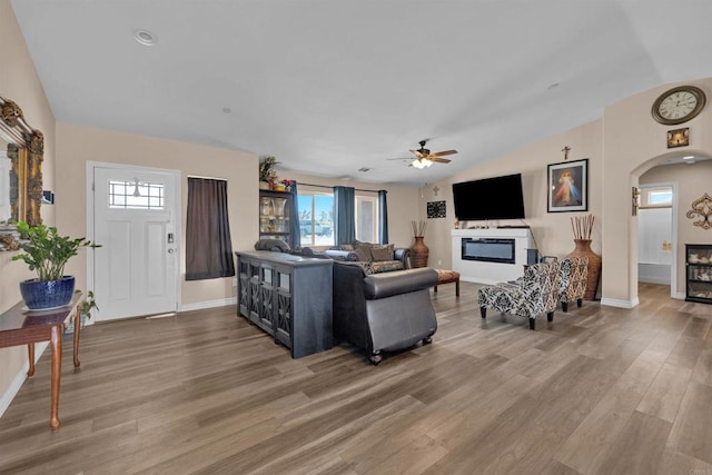 11374 Desert View Rd, Pinon Hills, CA 92372 - living area with light wood finished floors, a glass covered fireplace, baseboards, arched walkways, and vaulted ceiling