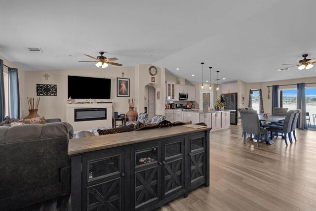 11374 Desert View Rd, Pinon Hills, CA 92372 - kitchen with dark cabinetry, ceiling fan, open floor plan, stainless steel microwave, and a kitchen island