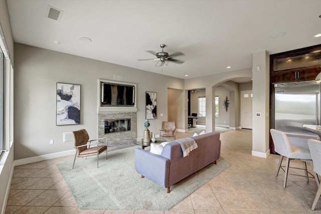 3522 Lancewood Way, Fallbrook, CA 92028 - living area featuring arched walkways, light tile patterned flooring, a ceiling fan, a glass covered fireplace, and baseboards