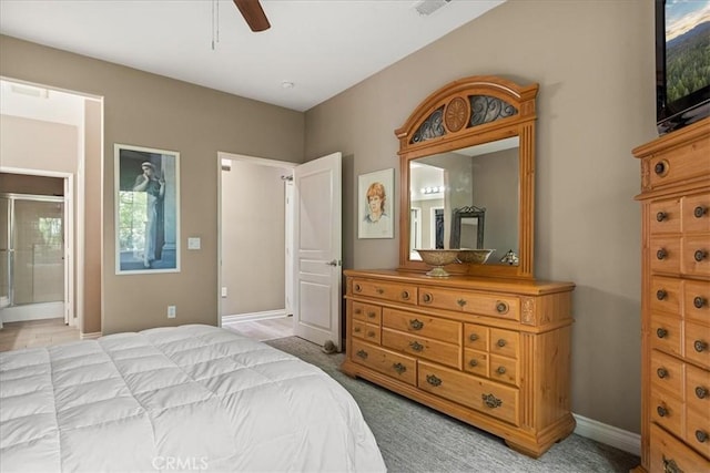 bedroom featuring light colored carpet, ensuite bath, baseboards, and ceiling fan