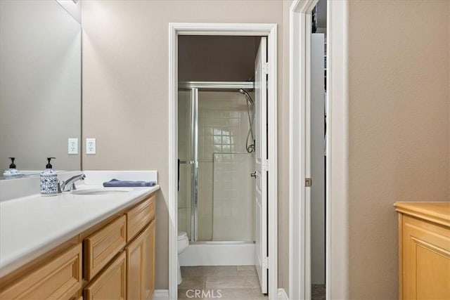 bathroom featuring vanity, a tile shower, and toilet