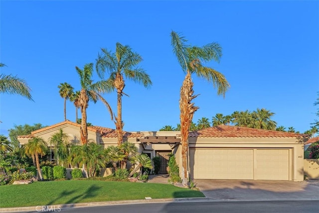 view of front of property featuring an attached garage, driveway, stucco siding, a tiled roof, and a front lawn