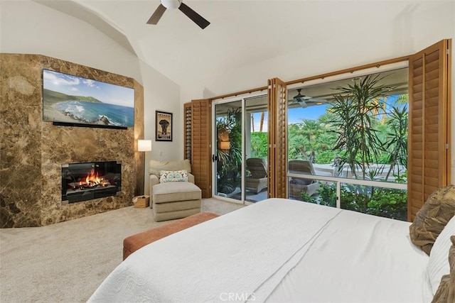 bedroom featuring access to outside, lofted ceiling, a fireplace, carpet floors, and a ceiling fan