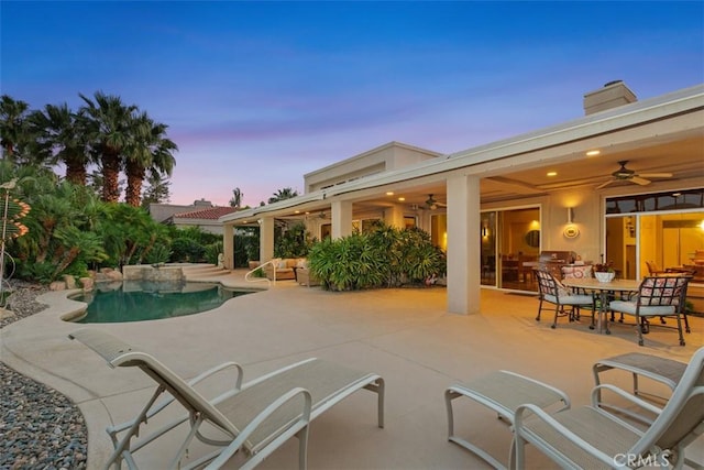 swimming pool with ceiling fan, a patio area, and outdoor dining space