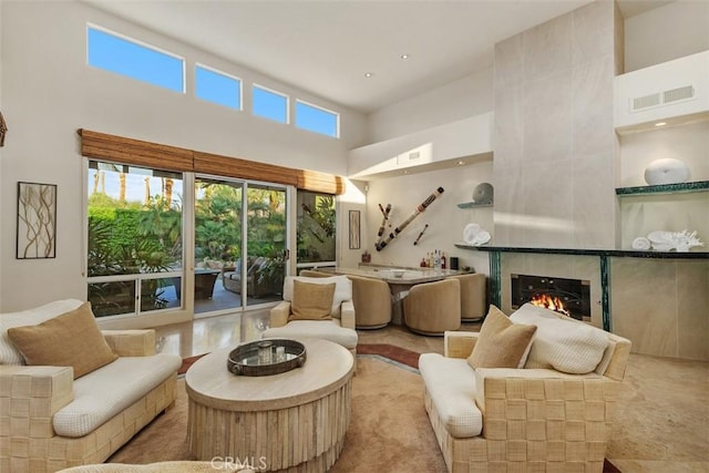 living area featuring a high ceiling and a fireplace