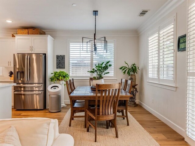 8670 Erika Ct, Atascadero, CA 93422 - dining area featuring healthy amount of natural light, a chandelier, light wood finished floors, ornamental molding, and baseboards