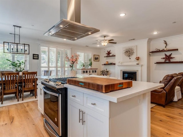 8670 Erika Ct, Atascadero, CA 93422 - kitchen featuring island range hood, gas range, ornamental molding, open floor plan, and light wood finished floors