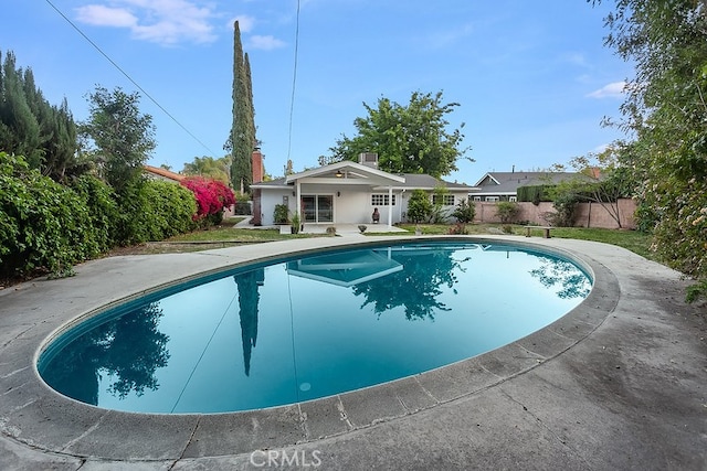 view of swimming pool featuring fence