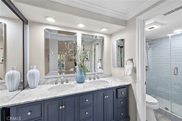 full bathroom featuring a stall shower, ornamental molding, double vanity, and toilet
