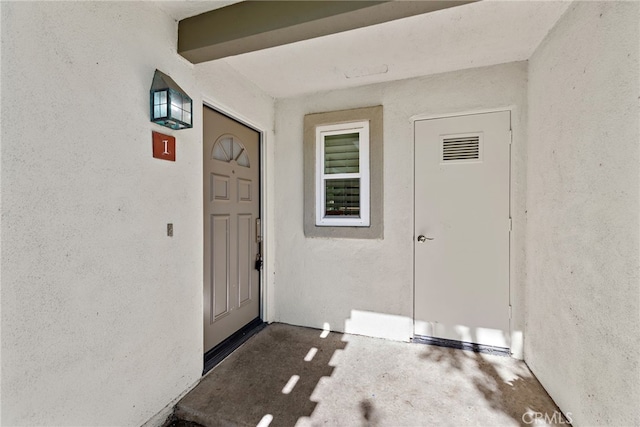 entrance to property with stucco siding