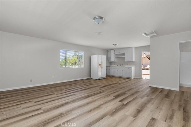 9019 San Gabriel Rd, Atascadero, CA 93422 - unfurnished living room with attic access, light wood-style flooring, baseboards, and a sink