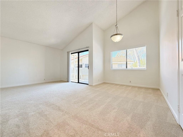 empty room with high vaulted ceiling, light colored carpet, a textured ceiling, and baseboards