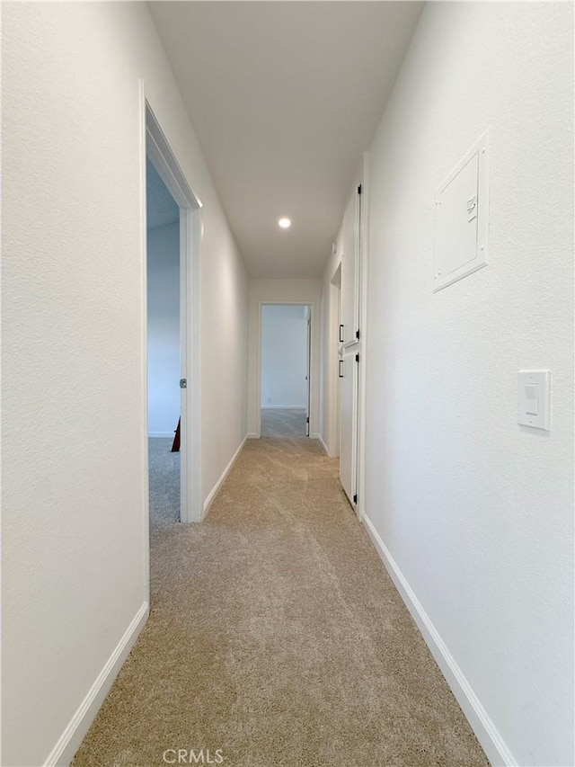 corridor featuring light carpet, baseboards, and recessed lighting