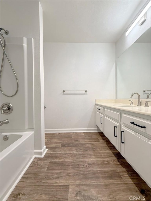 full bathroom featuring vanity, shower / tub combination, wood finished floors, and baseboards
