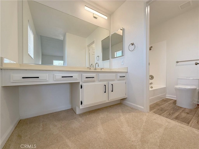 bathroom featuring toilet, baseboards, vanity, and shower / tub combination