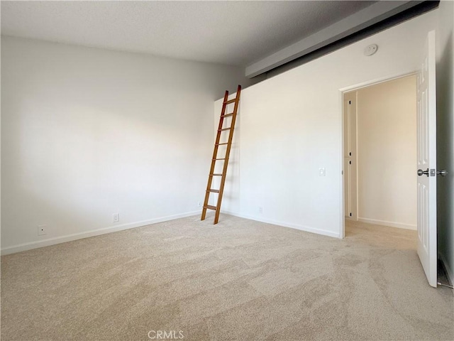 spare room with carpet and baseboards