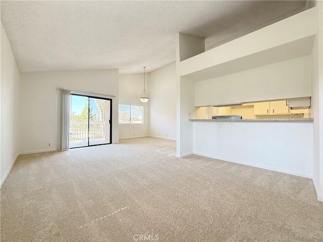 unfurnished living room with carpet flooring, a textured ceiling, baseboards, and high vaulted ceiling
