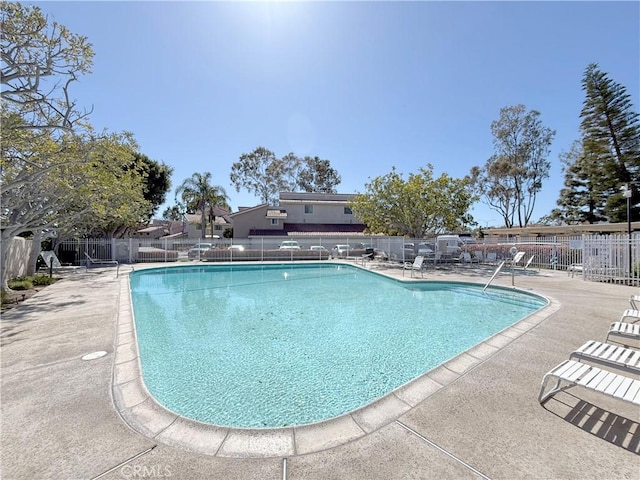 community pool featuring fence and a patio
