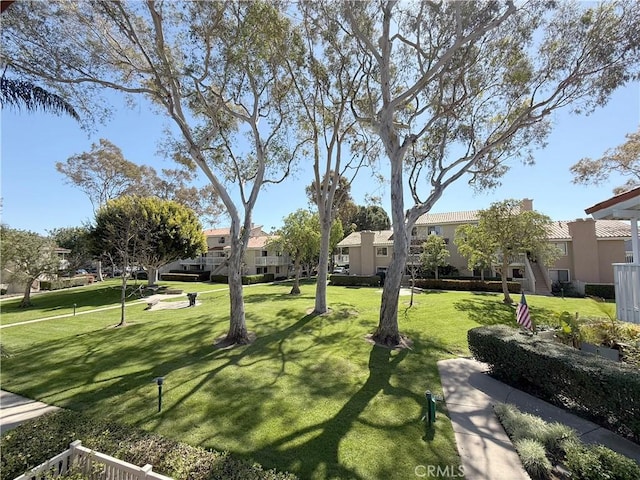 view of property's community featuring a yard and a residential view
