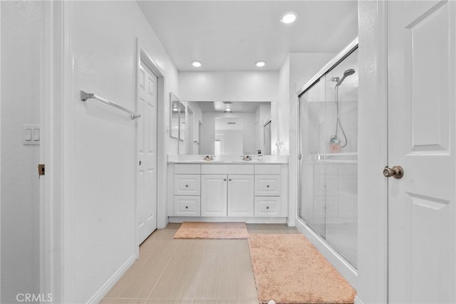 bathroom with a shower stall, vanity, and recessed lighting