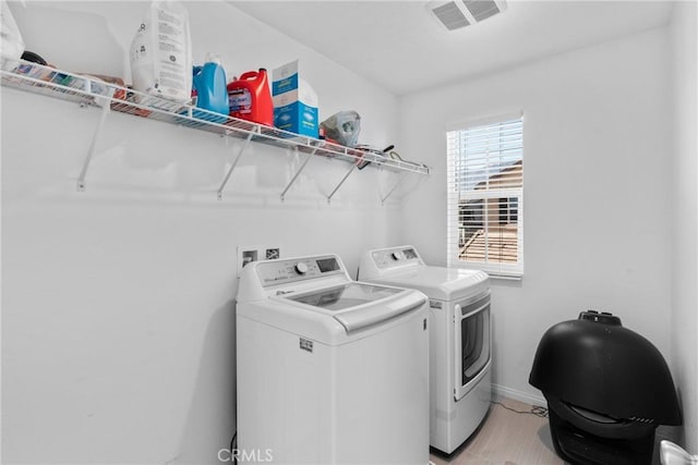 clothes washing area with washing machine and clothes dryer and baseboards