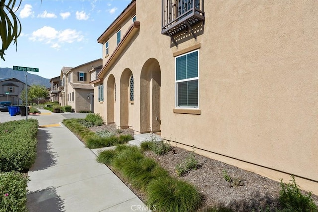 doorway to property featuring stucco siding, a residential view, and a balcony