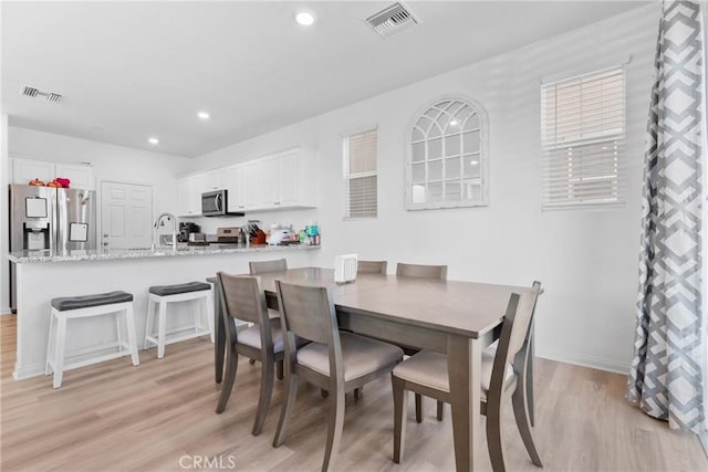 dining room with light wood-style floors and recessed lighting