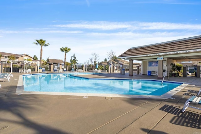 community pool featuring a patio and fence