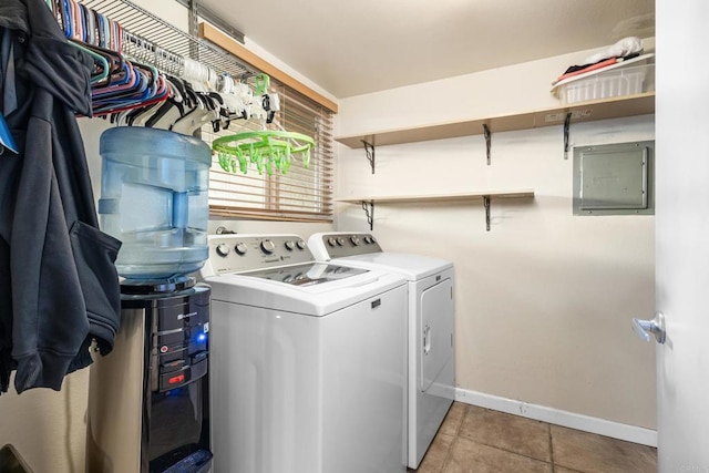 washroom featuring baseboards, light tile patterned floors, electric panel, washer and clothes dryer, and laundry area