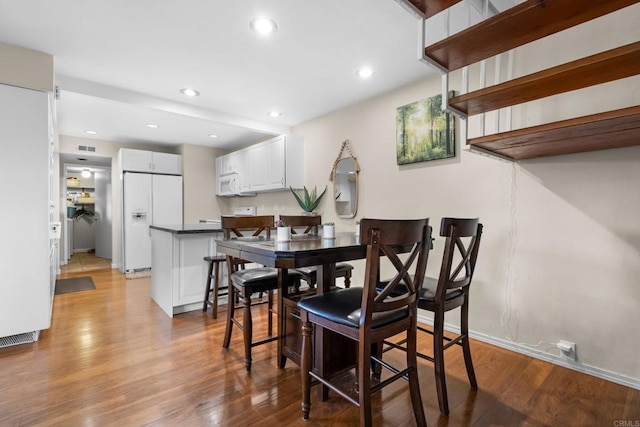 dining room with recessed lighting, baseboards, visible vents, and light wood-style floors
