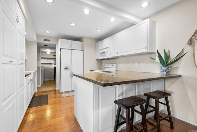17438 Ashburton Rd, Rancho Bernardo San Diego, CA 92128 - kitchen featuring white appliances, a peninsula, white cabinetry, recessed lighting, and a breakfast bar area