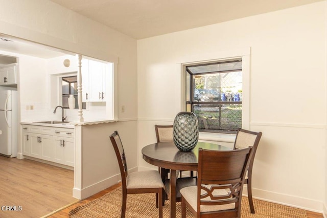 dining space featuring light wood finished floors and baseboards