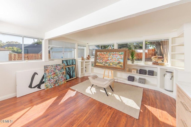 living area with wood finished floors and baseboards