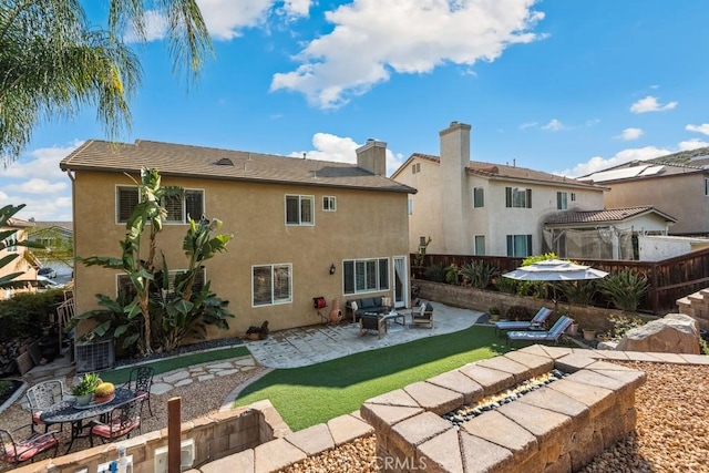 back of house featuring an outdoor fire pit, a patio, stucco siding, and fence