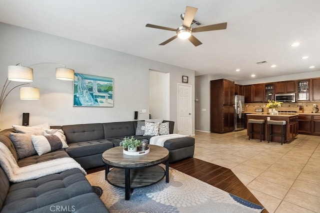 living room with a ceiling fan, recessed lighting, light tile patterned floors, and baseboards