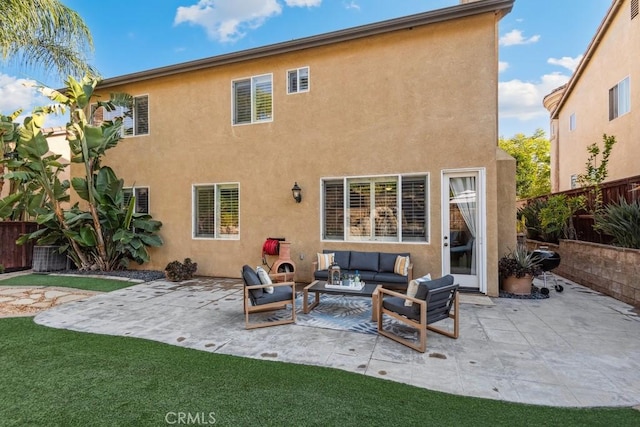 back of property with an outdoor living space, stucco siding, and a patio area