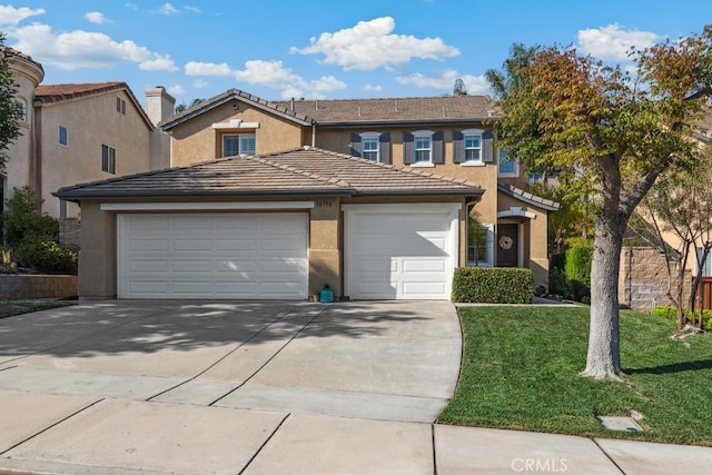 view of property featuring a garage, driveway, a front yard, and stucco siding