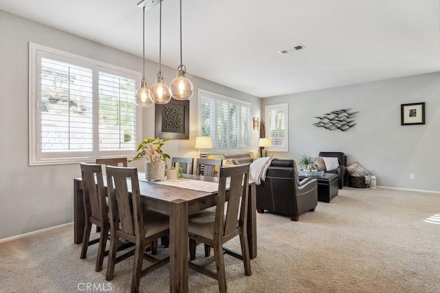 dining area with light colored carpet and baseboards