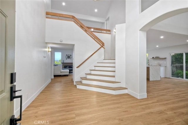 5166 Via Portola, Oceanside, CA 92057 - foyer featuring arched walkways, recessed lighting, wood finished floors, a towering ceiling, and stairs