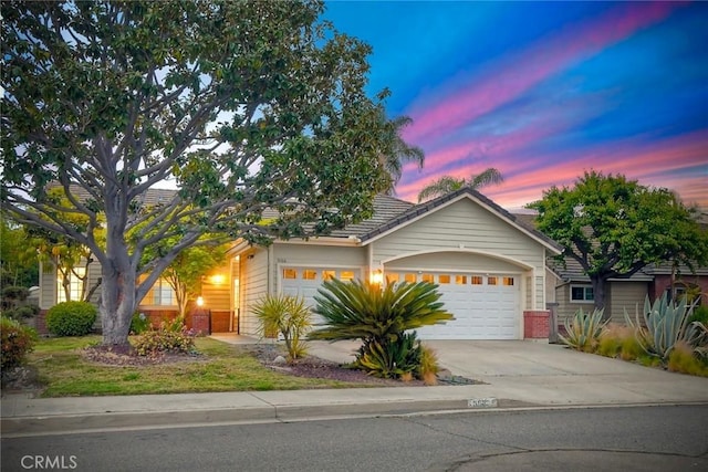 5166 Via Portola, Oceanside, CA 92057 - view of front facade featuring a garage, driveway, brick siding, and a tiled roof