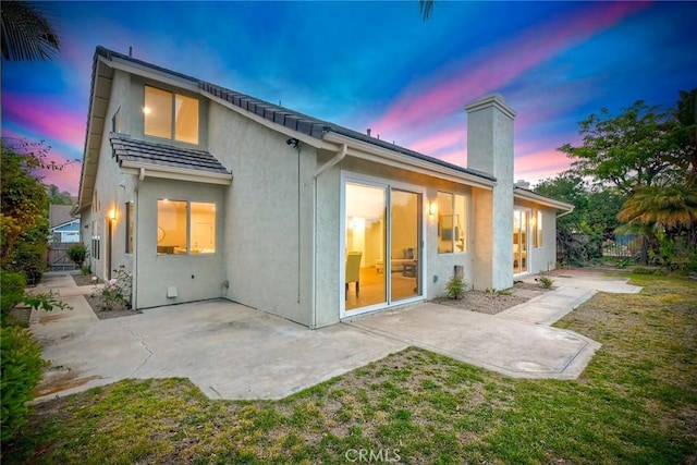 5166 Via Portola, Oceanside, CA 92057 - rear view of house featuring a chimney, stucco siding, and a patio