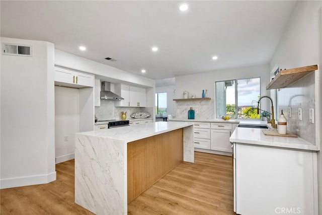 5166 Via Portola, Oceanside, CA 92057 - kitchen with open shelves, wall chimney exhaust hood, a kitchen island, a sink, and tasteful backsplash