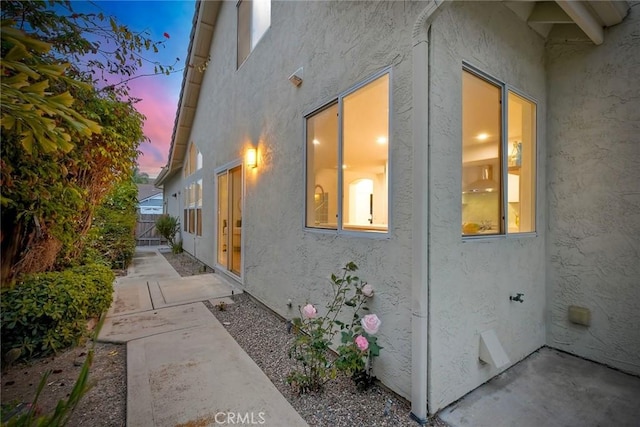 5166 Via Portola, Oceanside, CA 92057 - property exterior at dusk featuring stucco siding, a patio, and fence
