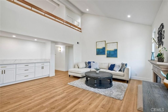 5166 Via Portola, Oceanside, CA 92057 - living room featuring light wood-style floors, high vaulted ceiling, recessed lighting, baseboards, and a glass covered fireplace