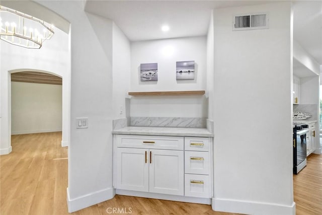 5166 Via Portola, Oceanside, CA 92057 - bar featuring range, light wood finished floors, arched walkways, baseboards, and a chandelier